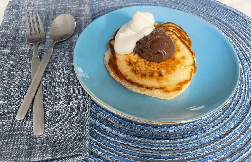 Pancake topped with nutella and whipped cream.