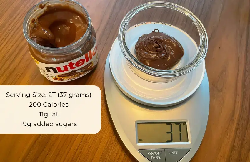 Nutella in bowl on scale to illustrate serving size of 37 grams.