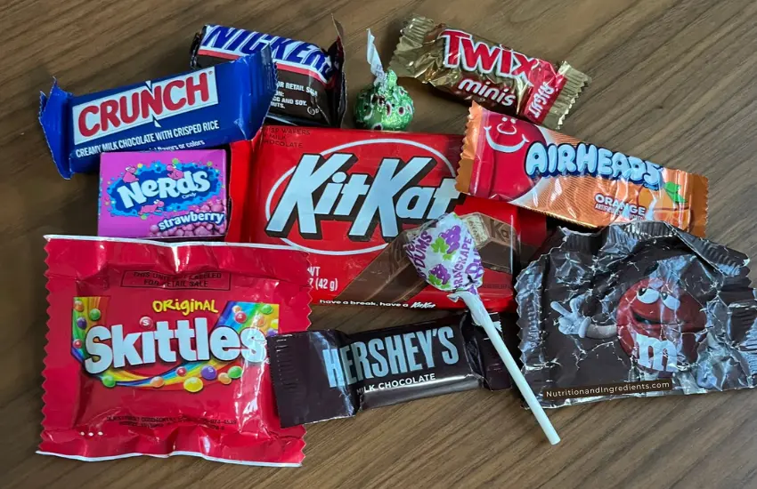 Small pile of chocolate bars, lollipops, and hard candies.