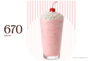 Glass filled with Chick-fil-A peppermint milkshake, whipped cream, and cherry.