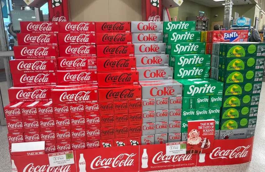 Stacked boxes of Coca-Cola and Sprite at grocery store.